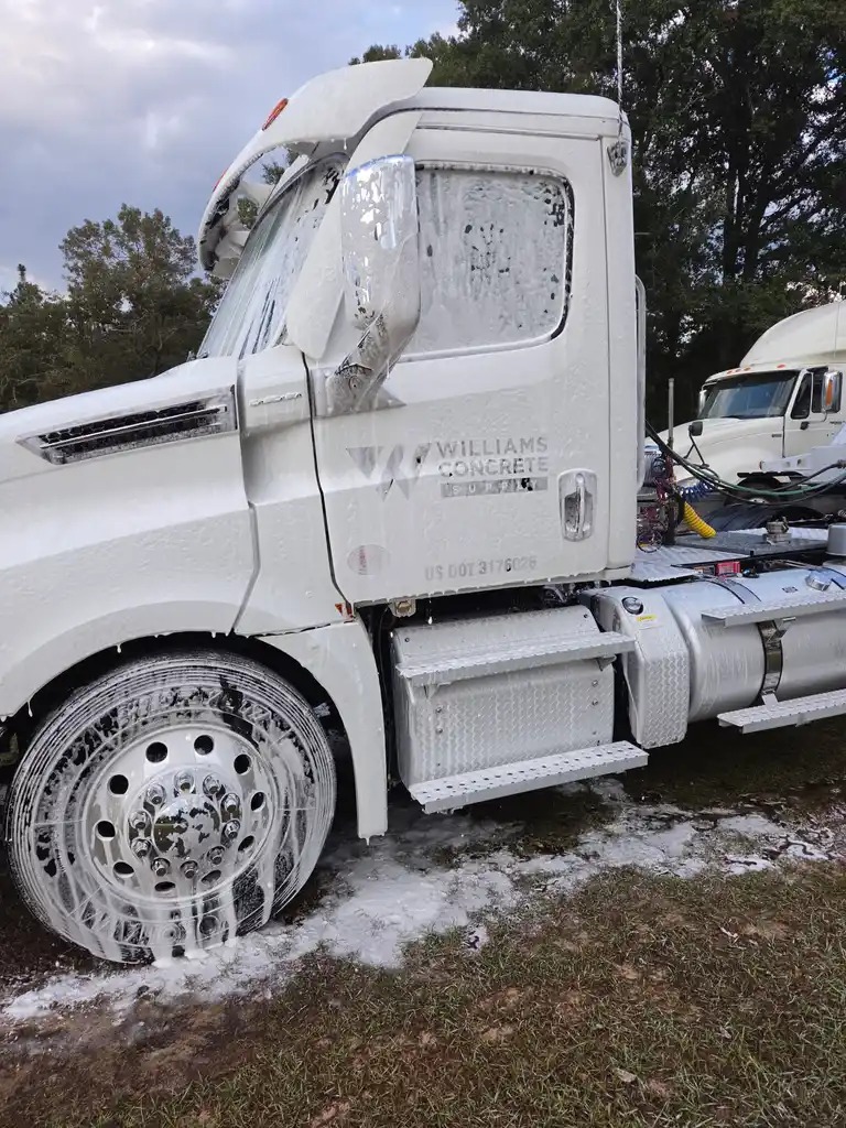 Red semi truck being pressure washed